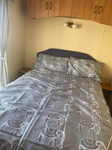 a bed with a blanket with horses on it at Pet Friendly Location Close To Beach in Ingoldmells