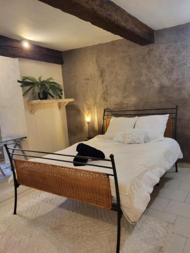 une chambre avec un grand lit avec des draps blancs dans l'établissement Appartement cosy au cœur des remparts, à Aigues-Mortes
