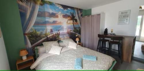 a bedroom with a bed with a painting on the wall at Le petit nid champêtre in Montesquieu-Lauragais