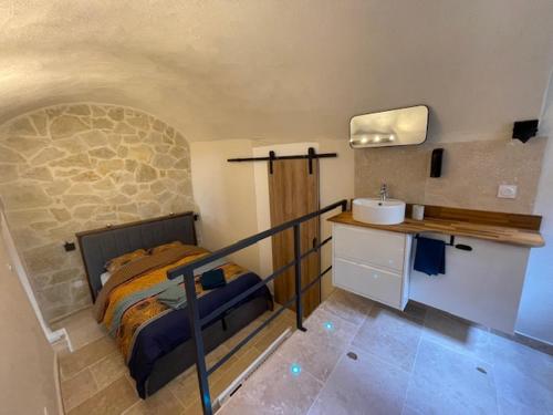 une chambre avec un lit et un lavabo dans l'établissement Face au théâtre antique - balnéo - jardin, à Orange