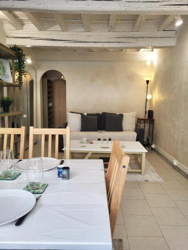 un salon avec une table blanche et un canapé dans l'établissement Appartement cosy au cœur des remparts, à Aigues-Mortes