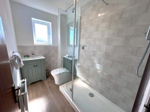 a bathroom with a shower and a toilet and a sink at Anchorage - Quaint and Cosy Two-Bedroom House in Poole