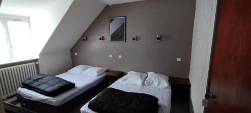 deux lits dans une petite pièce avec dans l'établissement Villa Mon Repos 5, à La Bourboule