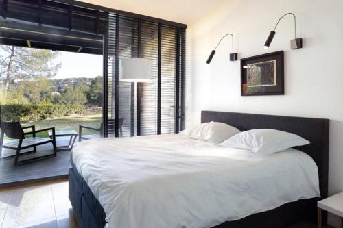 une chambre avec un grand lit et une grande fenêtre dans l'établissement Sublime villa moderne de luxe, à Saint-Gély-du-Fesc