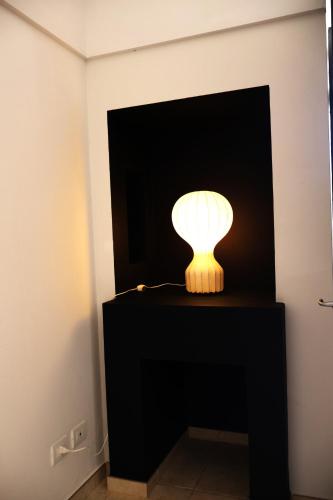a lamp sitting on a black table in a room at IL CARRUBO La dimora in Monopoli