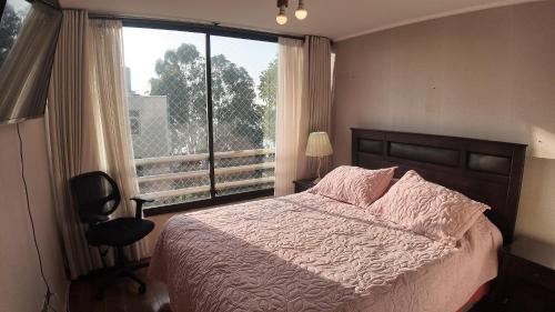 a bedroom with a bed and a large window at Departamento Familiar en Concón in Concón