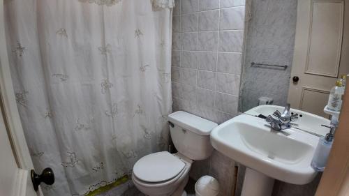 a bathroom with a toilet and a sink at Departamento Familiar en Concón in Concón