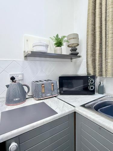 a kitchen with a counter top with a toaster and a sink at Alfie's Den, Bridlington in Bridlington