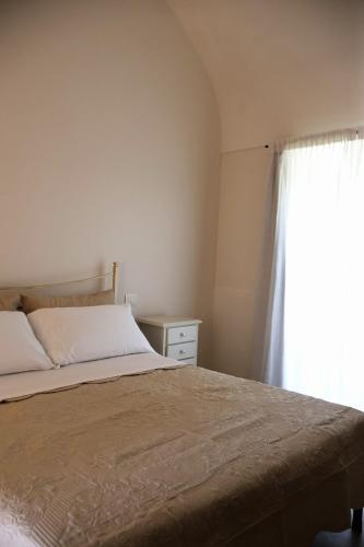 a bedroom with a bed and a window at IL CARRUBO La dimora in Monopoli