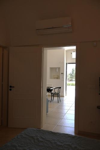 a room with a door and a dining room with a table at IL CARRUBO La dimora in Monopoli