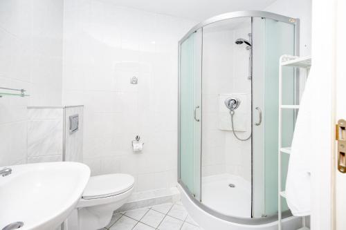 un bagno con doccia, WC e lavandino di Click Apartamenty Portowa a Kołobrzeg