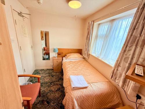 a bedroom with two beds and a window at Near Hylands hotel single room with shared WC in Nottingham