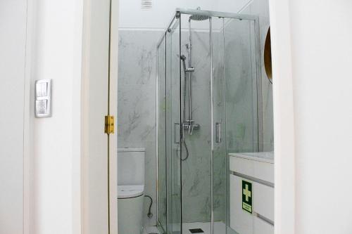 a glass shower in a bathroom with a toilet at São Pedro City Flat in Vila Real