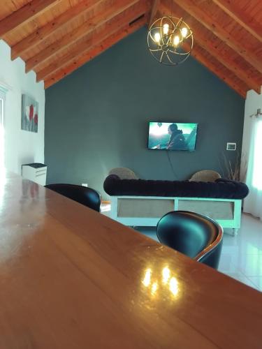 a dining room with a table and chairs and a couch at Chalet Liwen in San Martín de los Andes