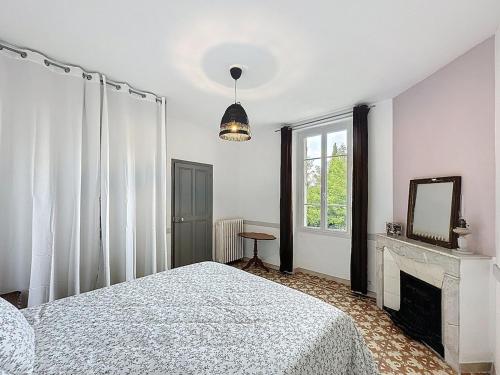 - une chambre avec un lit, une cheminée et un miroir dans l'établissement Les Gîtes de la Fée 3 Bedrooms Pool, à Cavaillon