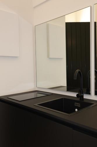 a kitchen counter with a sink and a mirror at IL CARRUBO La dimora in Monopoli