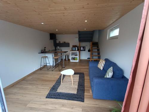 un salon avec un canapé bleu et une table dans l'établissement Studio en duplex 24H du Mans, à Étival-lès-Le Mans