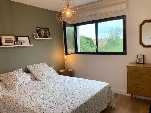 une chambre avec un lit et une fenêtre dans l'établissement Maison Moderne 600m virage mulsanne, à Mulsanne