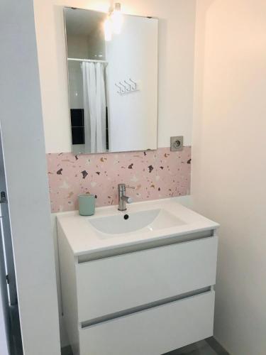 une salle de bain avec un lavabo blanc et un miroir dans l'établissement Maison Moderne 600m virage mulsanne, à Mulsanne