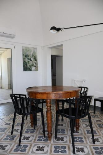 a wooden table and chairs in a room at IL CARRUBO La dimora in Monopoli