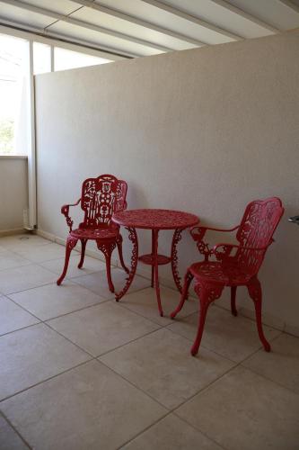 two red chairs and a table in a room at IL CARRUBO La dimora in Monopoli