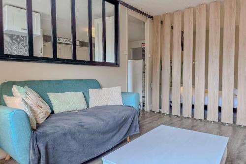 un salon avec un canapé bleu et une table dans l'établissement #HY Le Petit Metz City center, à Grenoble