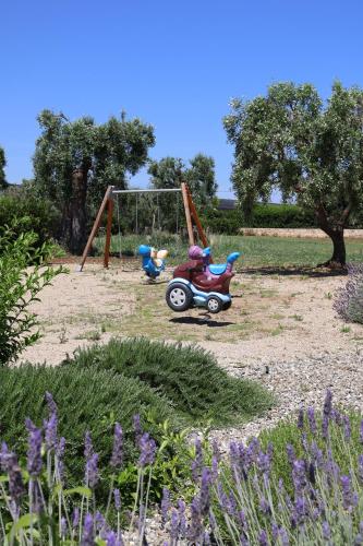 two toys on a swing set in a park at IL CARRUBO La dimora in Monopoli