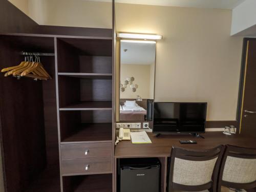 a room with a desk with a computer and a mirror at CE Plaza Hotel in Siófok