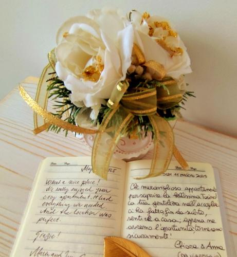 a book with a bouquet of flowers on top of it at Calin Apartment in Turin