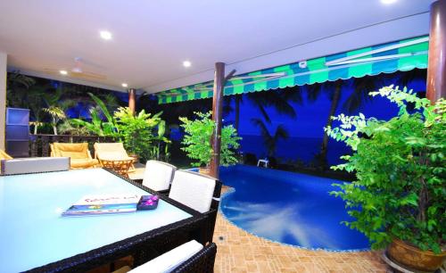 a patio with a table and chairs and a pool at Beachfront Oasis with Private Pool and Jacuzzi on Samuis Bang Por Beach in Ban Bang Po
