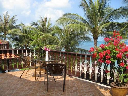 a balcony with a table and chairs and the ocean at Beachfront Oasis with Private Pool and Jacuzzi on Samuis Bang Por Beach in Ban Bang Po