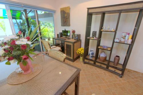 a living room with a table with a vase of flowers at Beachfront Oasis with Private Pool and Jacuzzi on Samuis Bang Por Beach in Ban Bang Po