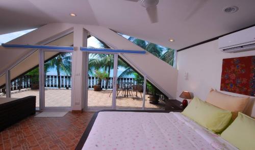 a bedroom with a bed and a large window at Beachfront Oasis with Private Pool and Jacuzzi on Samuis Bang Por Beach in Ban Bang Po