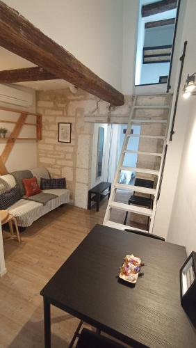 un salon avec une table et un escalier en colimaçon dans l'établissement Iris, 4 personnes, centre pieton Ecusson, Tram, 3ème étage sans ascenseur, à Montpellier