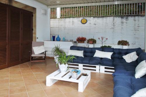 a living room with a blue couch and a table at Villa DAMMUSO by Local House - private villa infinity pool & seaview in Santo Stefano di Camastra