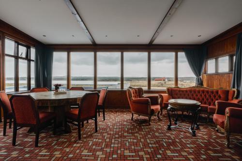 a dining room with a table and chairs and windows at Hotel Kriunes in Reykjavík