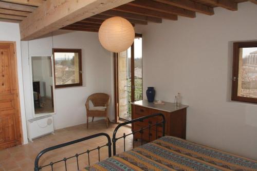 une chambre avec un lit, un bureau et une lampe dans l'établissement Le Petit Paradis, à Boulbon