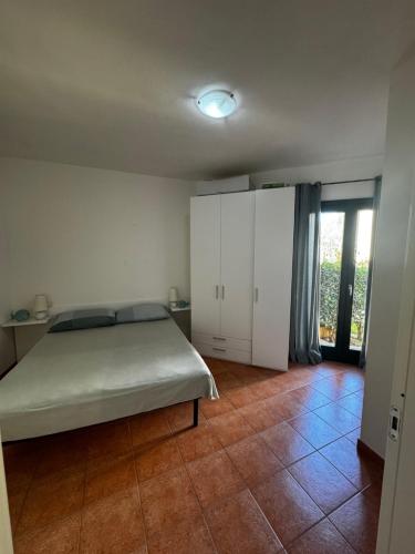 a bedroom with a bed and white cabinets and a tile floor at Casa Maedo in Santa Maria