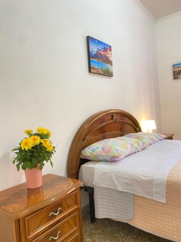 a bedroom with a bed and a vase of flowers on a table at Casa Linda in Lido di Ostia