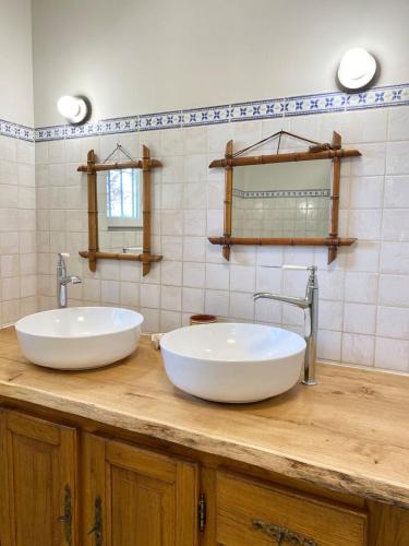 deux lavabos sur un comptoir en bois dans une salle de bain dans l'établissement Longère de charme - Périgord, à Vergt