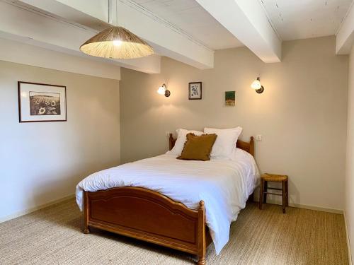 une chambre avec un grand lit avec des draps blancs dans l'établissement Longère de charme - Périgord, à Vergt