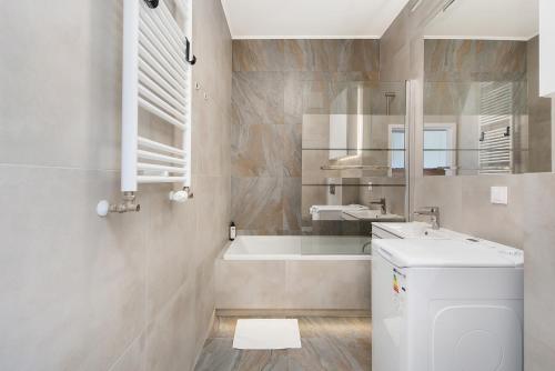 a bathroom with a tub and a sink and a toilet at Central Apartments by Bed&Bath in Kraków