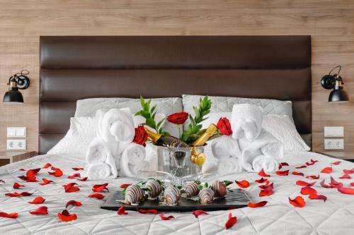 a bed with red flowers and white towels on it at Hotel Kriunes in Reykjavík
