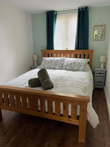 a bedroom with a wooden bed with two pillows on it at Hanley Swan, The Garden Flat in Madresfield