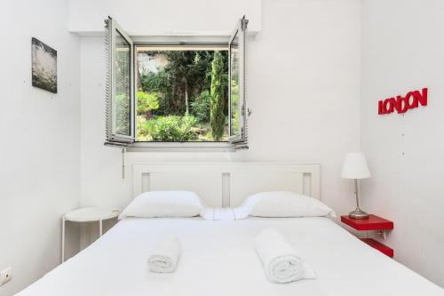 une chambre avec un lit blanc et une fenêtre dans l'établissement Frontière avec Monaco - Balcon avec vue mer - Parking - DO, à Beausoleil