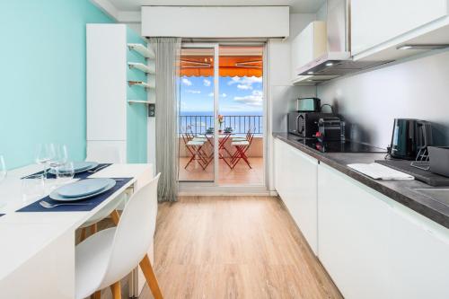 une cuisine avec comptoirs blancs et vue sur l'océan dans l'établissement Frontière avec Monaco - Balcon avec vue mer - Parking - DO, à Beausoleil