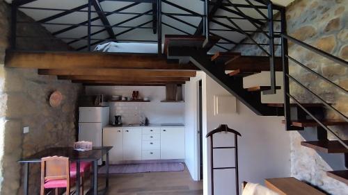 a kitchen with a staircase leading up to a loft at Quinta da Regada in Arcos