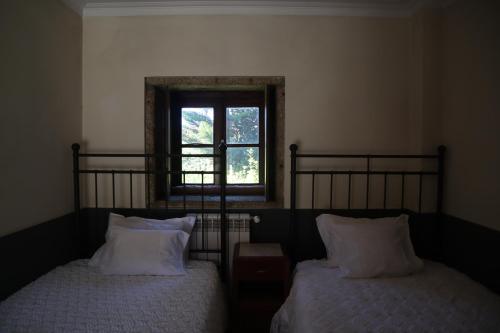 a bedroom with two beds and a window at Quinta da Regada in Arcos