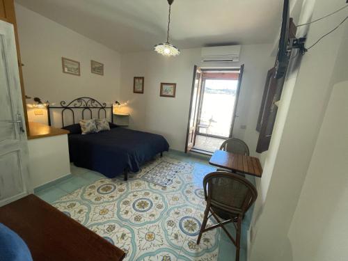 a bedroom with a bed and a table and a window at Diana Brown B&B Affittacamere in Lipari