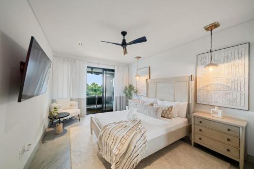 biała sypialnia z łóżkiem i telewizorem w obiekcie Allure 101 condo w mieście Bridgetown